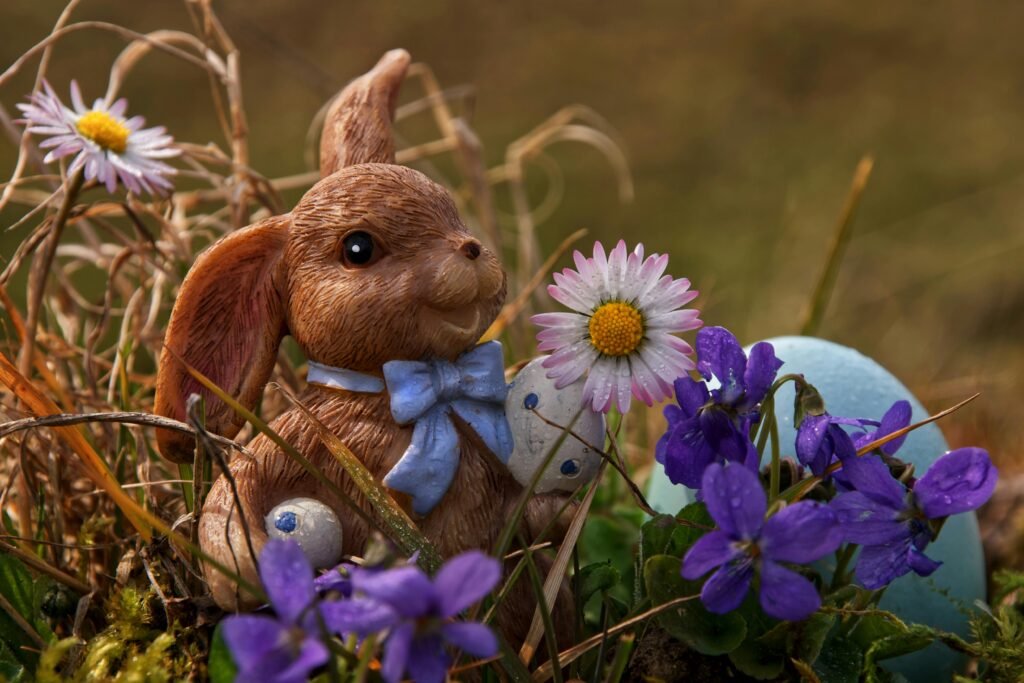 Delightful Easter bunny figurine among vibrant spring flowers and Easter egg, perfect festive decor.
